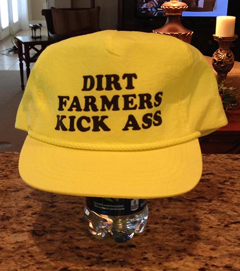 Yellow billed cap bearing the words DIRT FARMERS KICK ASS
