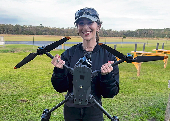 woman holding a drone in a field